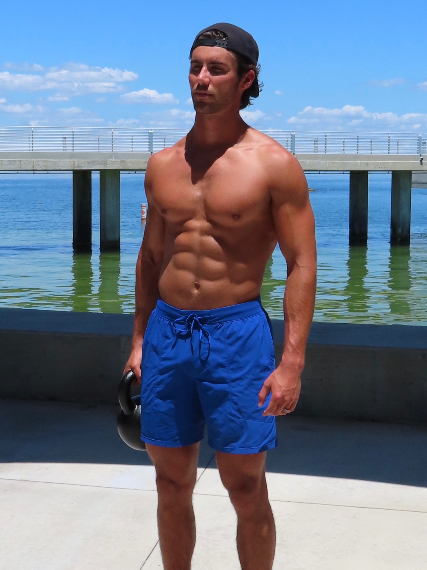 Murph holding a kettlebell on a waterfront pier
